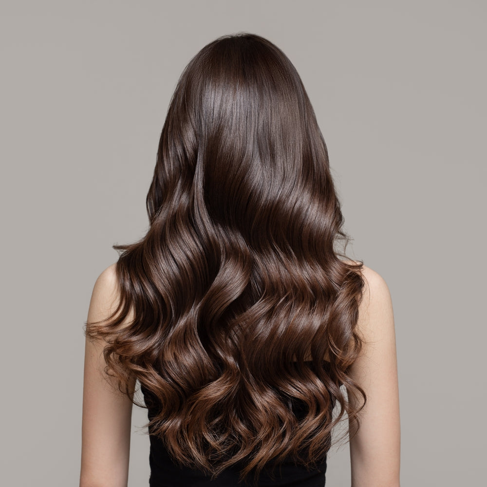 Woman with long, glossy brown hair showcasing Elmore hair color results