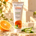 Elmore Vitamin C Glowing Daily Face Wash beside fresh orange and aloe vera with water splashes on a stone platform.