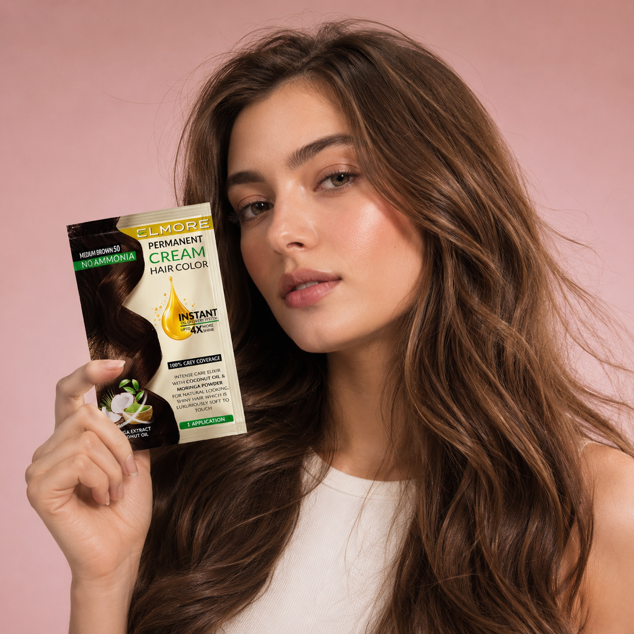A woman with long, wavy medium brown hair holds up a package of Elmore Permanent Cream Hair Color against a solid pink background.
