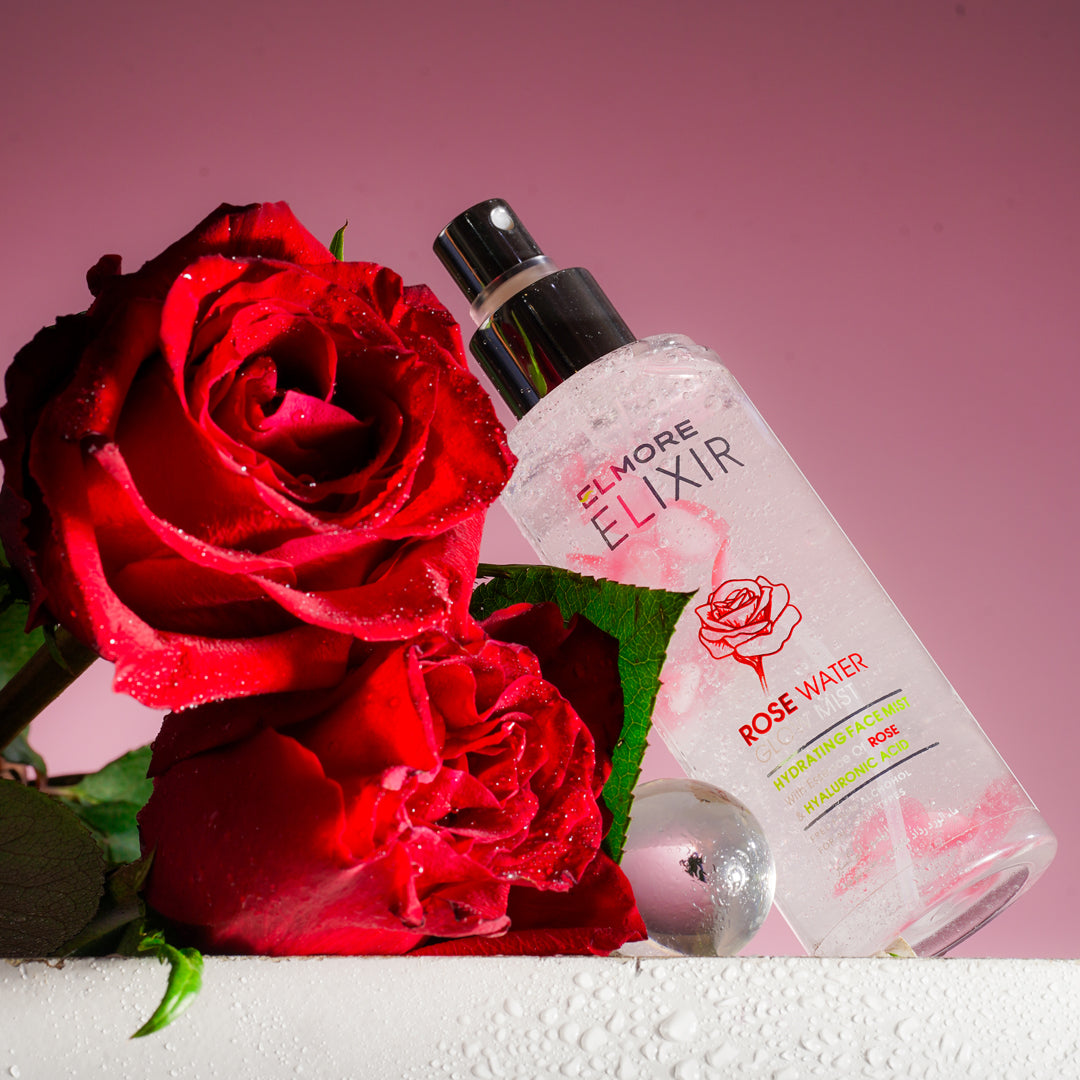 Bottle of Elmore Elixir rose water with red roses on a pink background